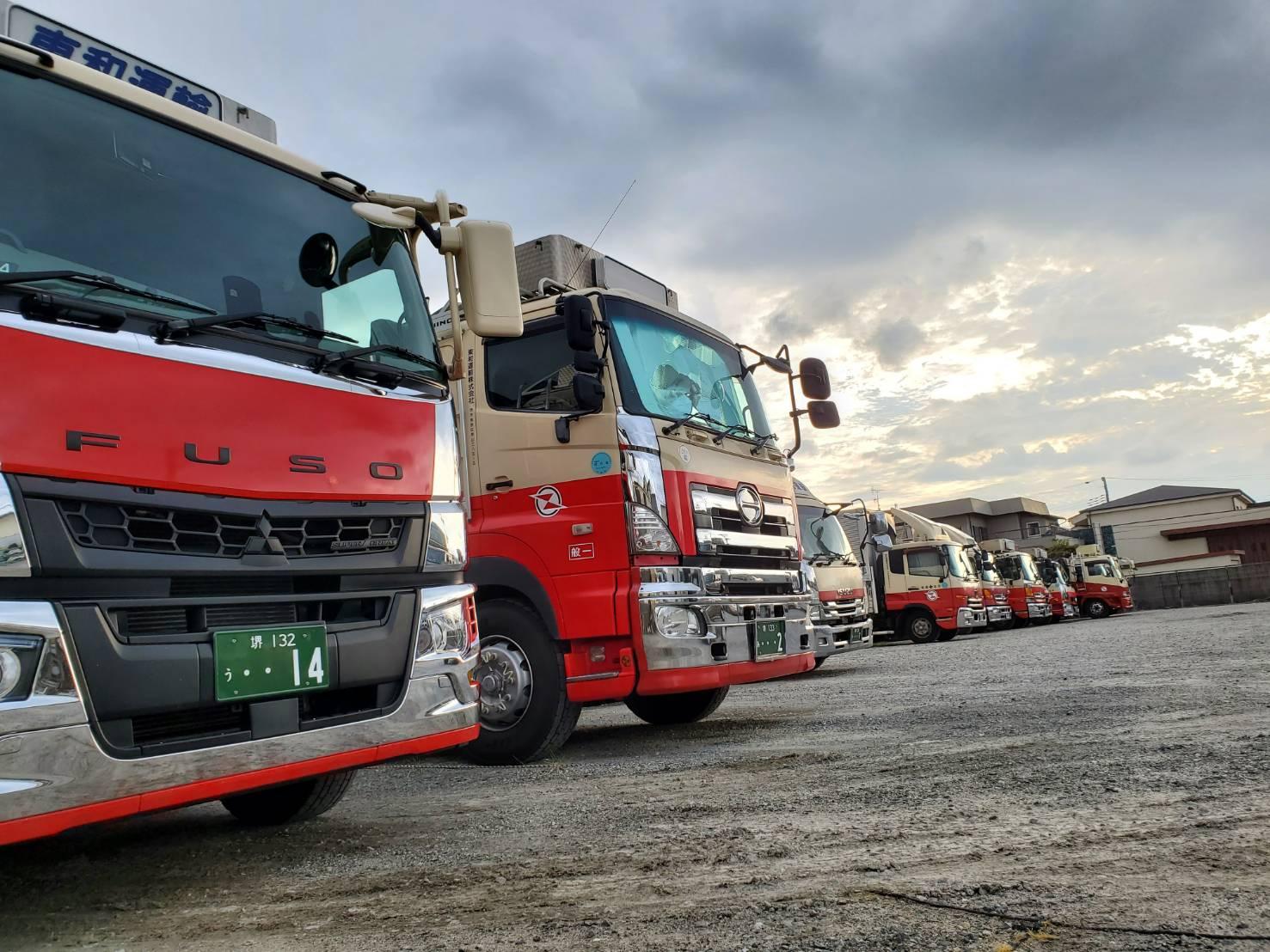 「地域物流を支える東和運輸」 たくさんのトラックが並ぶ当社の車庫。安定した仕事量で、長く安心して働ける基盤があります。